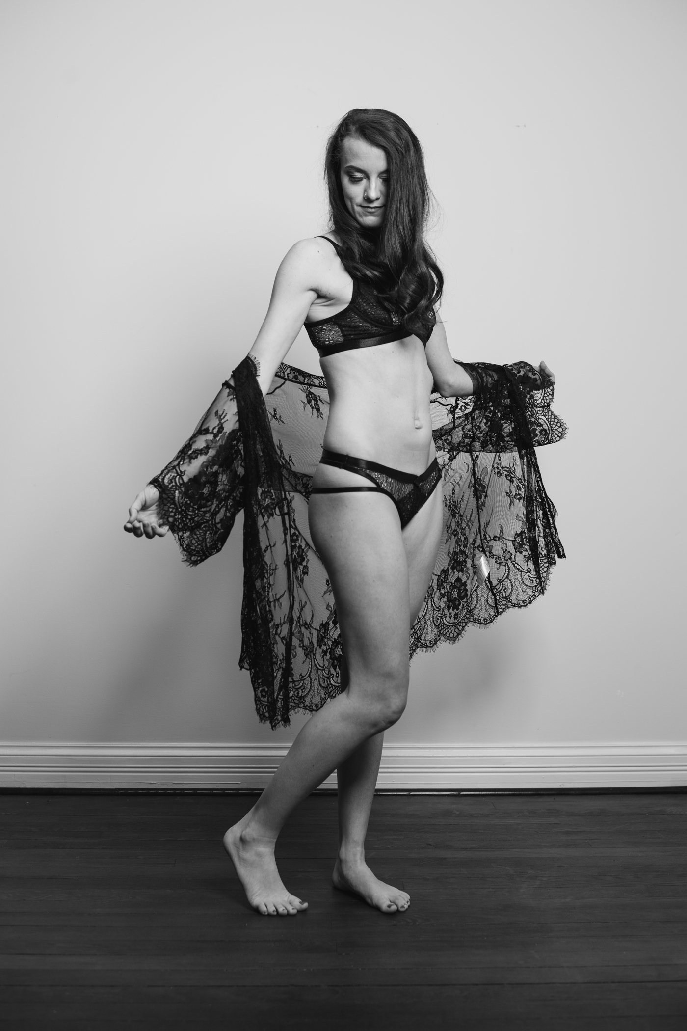 woman in black bra and panties holding a black lace robe